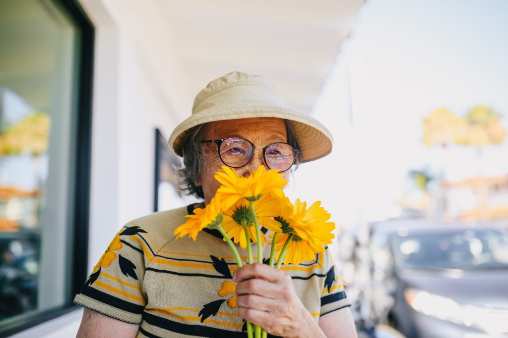 senior woman holding bouquet of sunflowers