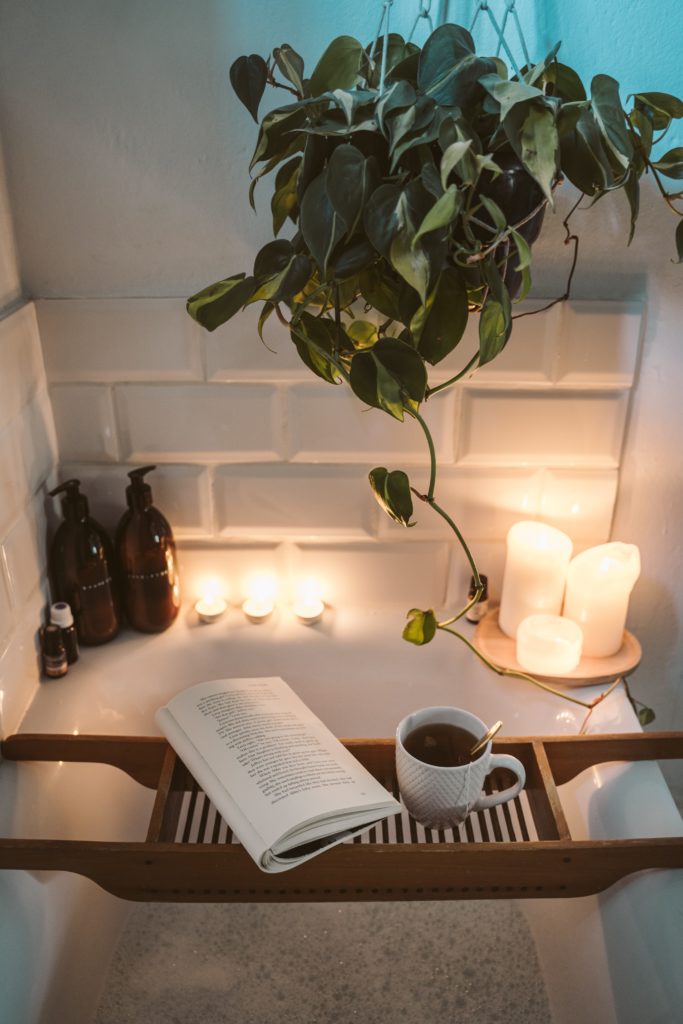 a plant in a vase next to a book and candles