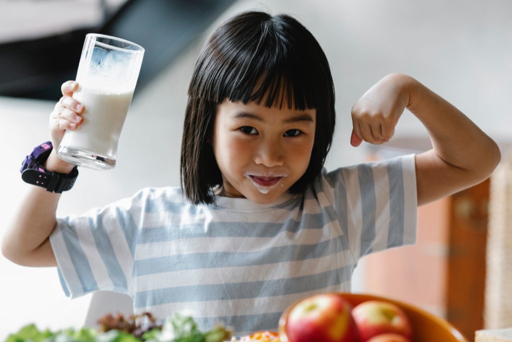 Child with milk mustache enjoying eating healthy.