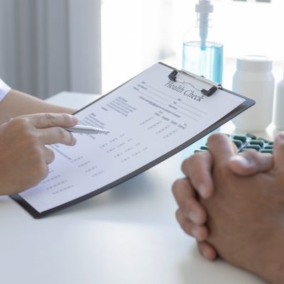 naturopathic doctor with clipboard during woman's health checkup.